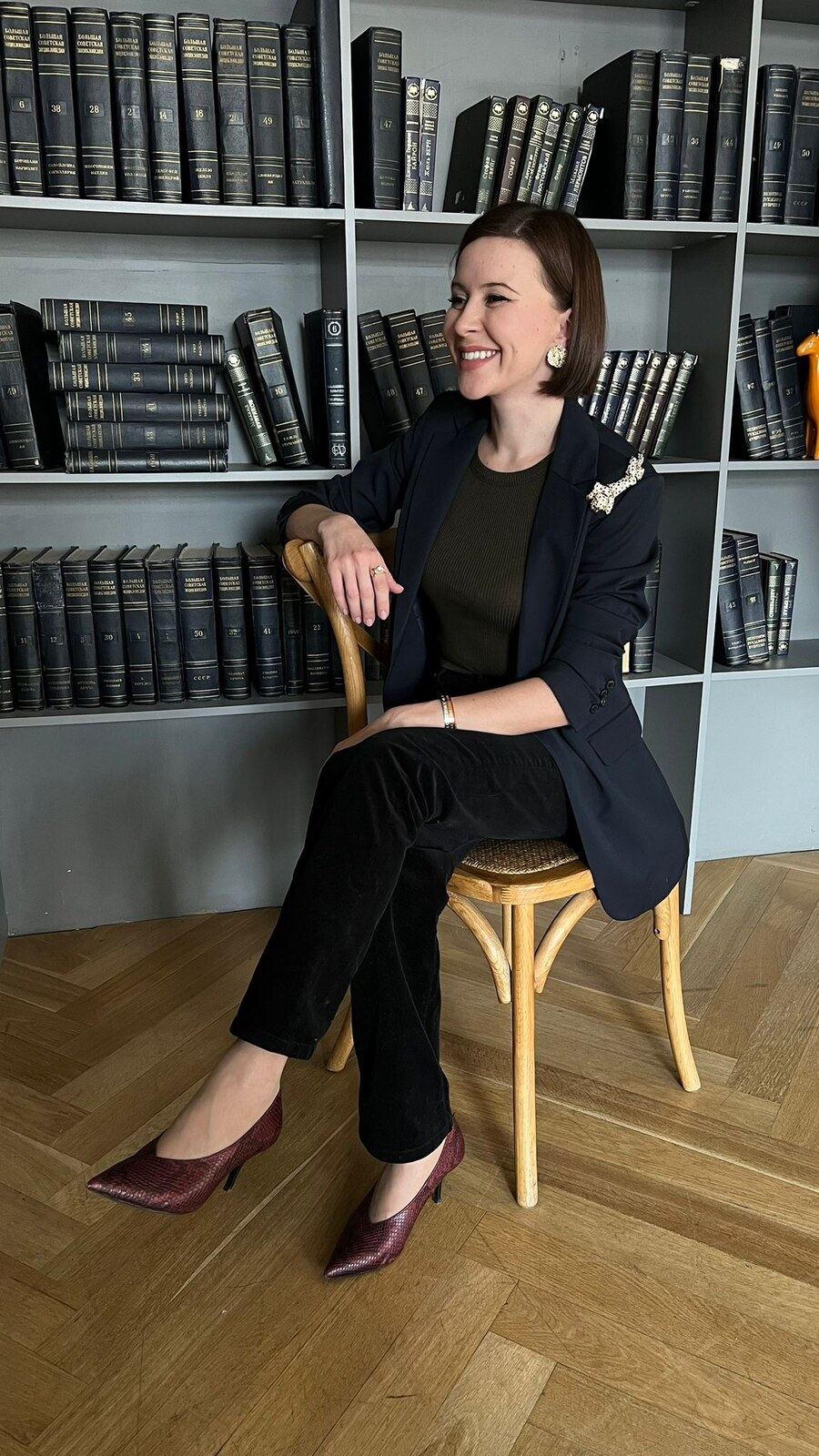 María Suprun sentada en una biblioteca