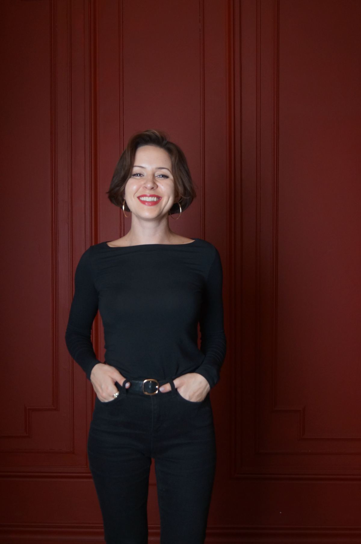 María Suprun sonriendo ante una pared burdeos